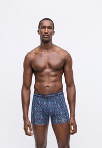 Vīriešu pieguļoši bokseršorti, ar daudzkrāsainu zigzaga rakstu, elastīgu audumu un tumšu jostasvietu ar zīmola nosaukumu "BJÖRN BORG."