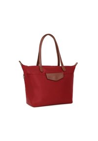 Borsa tote rossa in nylon con manici in pelle marrone e una tasca frontale. Presenta una forma strutturata e accenti hardware minimi.