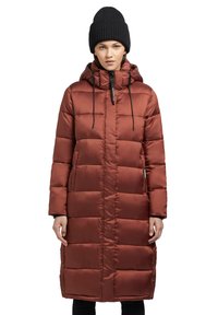 Long, padded coat in rust brown color with a hood, contrasting black zipper, and drawstrings; features a quilted texture and side pockets.