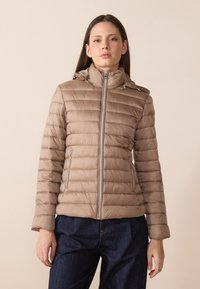Lys brun puffer-jakke med glidelås foran, hette og horisontal quilt. Har sølvfargete detaljer og to sidelommer med glidelås. Myk, glatt tekstur.