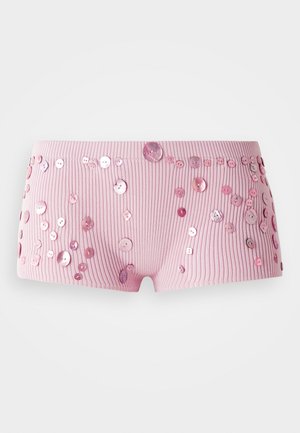 Roze geribbelde shorts versierd met verschillende maten glanzende roze knopen die over de stof verspreid zijn.