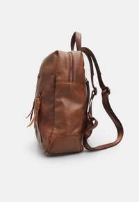 Zaino in pelle marrone con finitura texturizzata, chiusura con zip, spallacci regolabili e tasca laterale. Presenta dettagli in metallo.