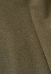 Tissu vert olive lisse avec une texture de tissage subtile et des plis doux créant des ombres douces.