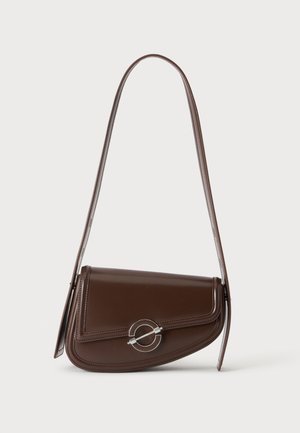 Sac à épaule en cuir marron avec rabat asymétrique et fermoir circulaire argenté, présenté sur un fond blanc uni.
