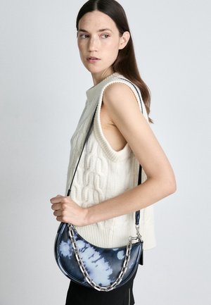 Torebka crossbody z niebieskiej tkaniny tie-dye z srebrnym łańcuszkowym paskiem. Zakrzywiony kształt, gładka faktura i zapięcie na zamek błyskawiczny.