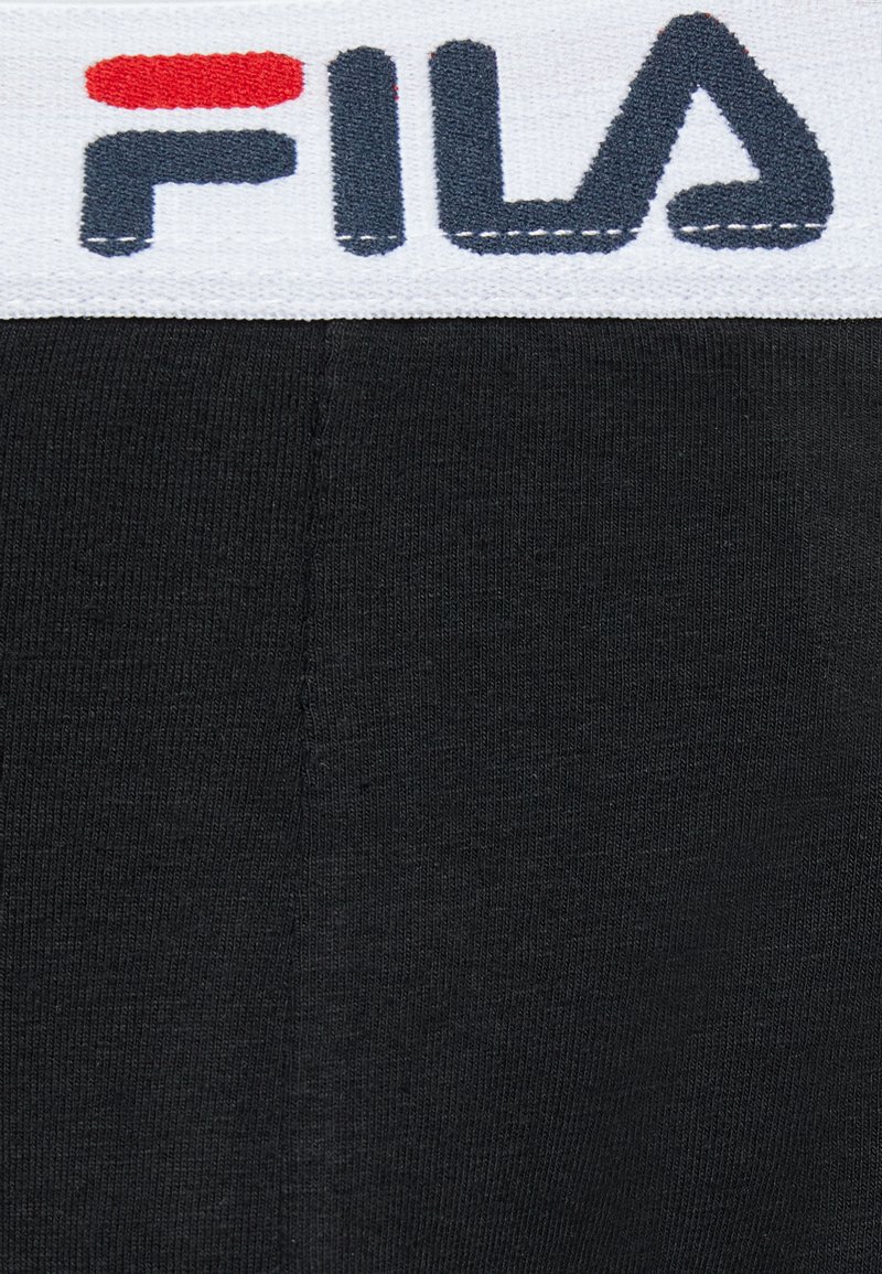 Tessuto nero con una superficie liscia, caratterizzato da una cintura elastica bianca con scritte rosse e blu che formano la parola "FILA." Cuciture uniformi.