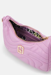 Sac à main en cuir rose avec une texture ondulée, fermeture éclair dorée et un fermoir géométrique. L'intérieur présente un motif léopard en vert et noir.