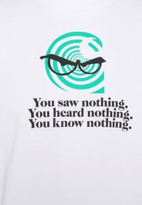 Camiseta de algodón blanca con un gráfico de líneas verdes en espiral y gafas negras, con el texto que dice: "No viste nada. No oíste nada. No sabes nada."