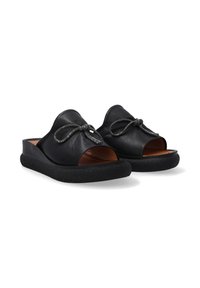 Zwarte leren open teen sandalen met een decoratieve strik, een gestructureerde zwarte zool en een gladde bruine inlegzool. Minimalistisch ontwerp met gebogen randen.
