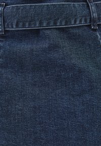 Mörkblå denimtyg med en subtil textur, med en bred bältesögla och ren sömnad längs midjan.