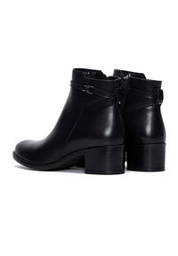 Bottes à cheville en cuir noir avec talons blocs bas et détail décoratif d'une sangle avec boucle, vues de côté et de dos.
