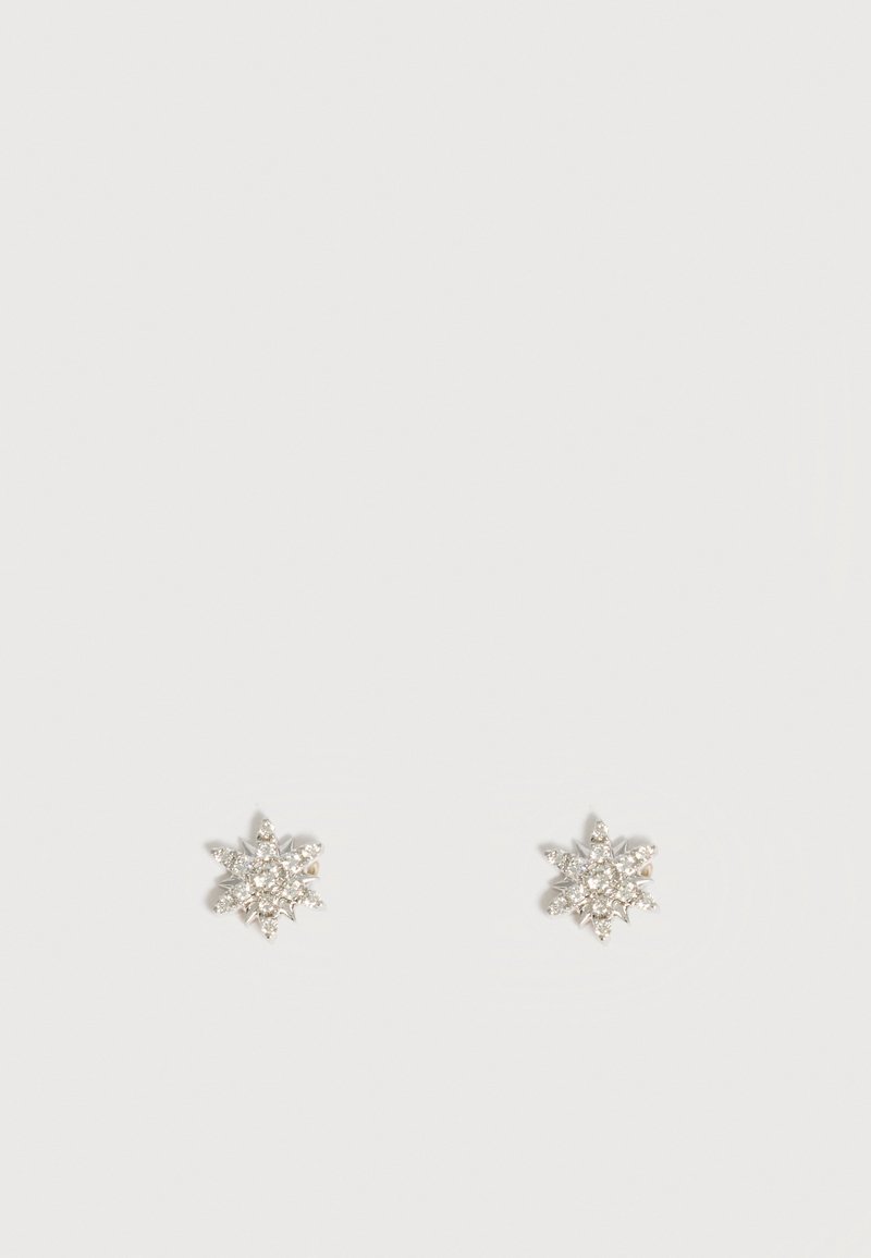 Boucles d’oreilles puces en forme d’étoile ton argent avec plusieurs petits cristaux clairs sur fond blanc uni.