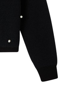 Czarny sweter o teksturowanym wykończeniu, z akcentami perłowymi i prążkowanymi mankietami. Design jest casualowy i ma dopasowany krój.