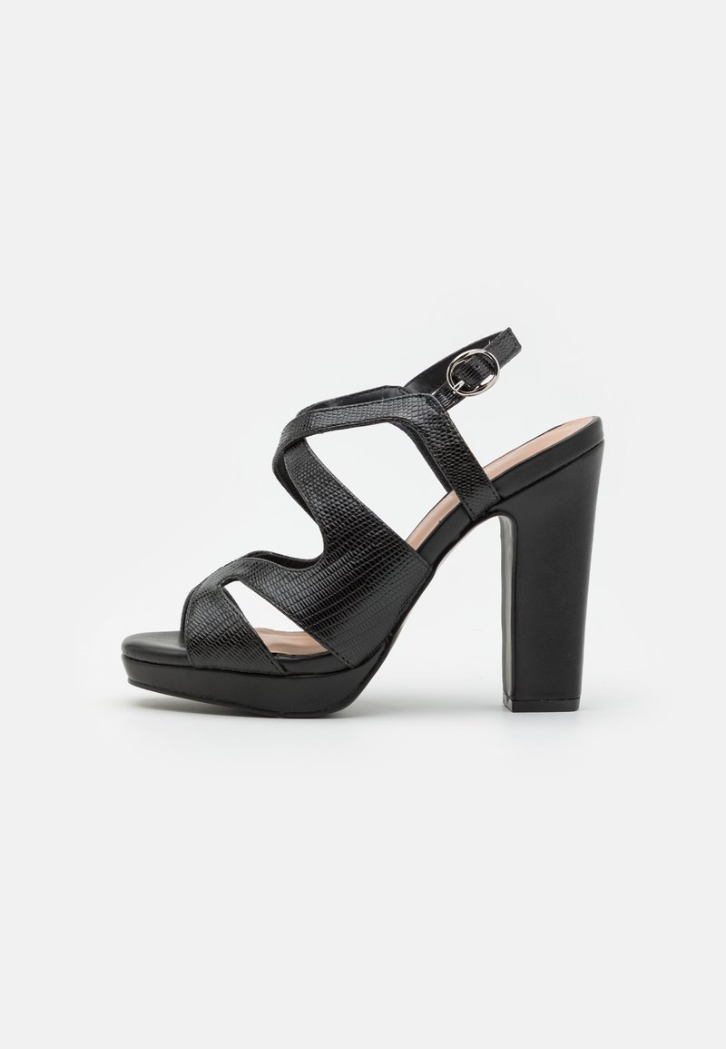 Sandales à talons hauts noires avec une tige texturée, bout ouvert, lanières courbes et une boucle à la cheville. Talon épais pour plus de stabilité.