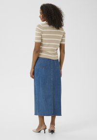 Beige and white striped short-sleeve knit top paired with a long dark blue denim skirt featuring back pockets and a straight cut.