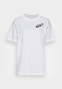 Vit kortärmad t-shirt i bomull med en svart Nike-logotyp med röd kontur och ett litet dekorativt inslag på vänster bröst.