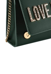 Borsa a tracolla in finta pelle verde con lettering "LOVE" in tonalità oro, tracolla a catena e chiusura magnetica con accentuazione rotonda sul lato.