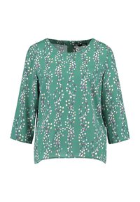 Grüne Bluse mit Dreiviertelärmeln, die ein florales Muster aus weißen und lila Blumen auf einem strukturierten Stoff zeigt. Quadrat-Ausschnitt.