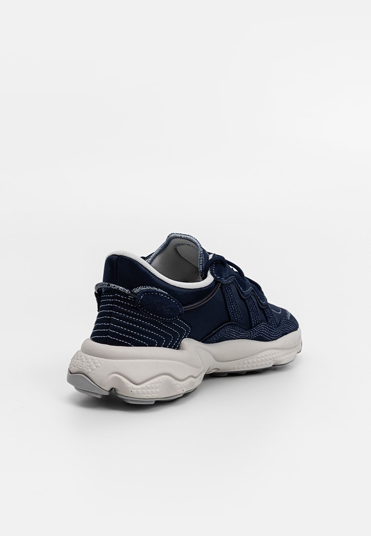 Sneaker da ginnastica blu navy con upper in tessuto testurizzato, colletto imbottito e suola bianca spessa. Presenta cuciture e accenti a contrasto.