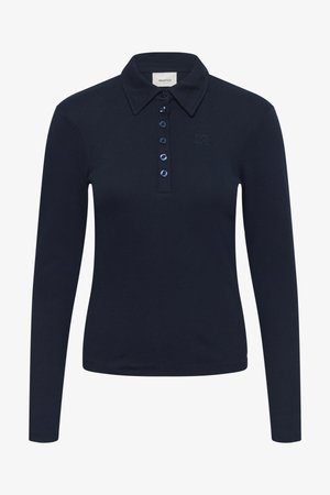 Tumesinist värvi soonikkoes pika varrukaga polo-särk, millel on krae, nööpide sulgemine siniste nööpidega ja peen logo detail.