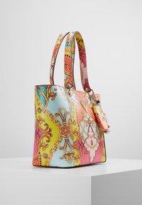 Kleurrijke tote bag met een mix van roze, geel en blauwe patronen met sierlijke gouden accenten en een kleine vastgezette tas. Gladde textuur.