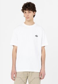 White cotton t-shirt with short sleeves and a round neckline, featuring a small black logo on the left chest.
