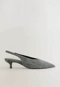 Melnas un baltas ķīļveida zābaku kurpes ar zigzaga rakstu, ar smailiem purngaliem, strukturētu virsu un noapaļotu 3 cm augstu papēdi.