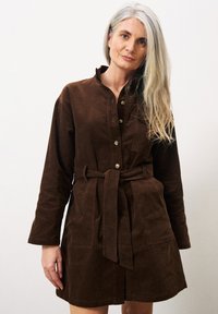 Braunes Cordkleid mit langen Ärmeln, Knopfleiste und gebundenem Taillengürtel. Verfügt über zwei Fronttaschen und ein kragenloses Design.