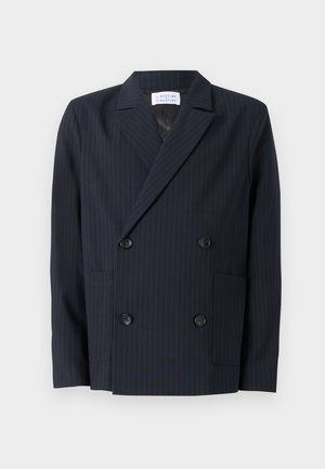 Dubbelzijdige blazer van donker marineblauw stof met verticale streepjes. Voorzien van grote zwarte knopen en twee voorzakken. Getailleerd ontwerp.