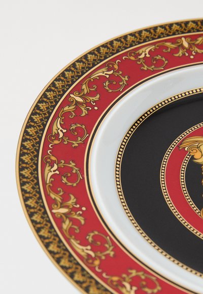 Ceramiczny talerz z czerwonymi, czarnymi i złotymi ozdobnymi wzorami; posiada misternie wykonane kwiatowe motywy i błyszczące wykończenie. Okrągły kształt, szczegółowo zdobiona krawędź.