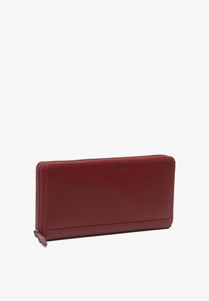 Portefeuille rectangulaire en cuir rouge foncé avec fermeture éclair sur le dessus et les bords latéraux, embossé d'un petit texte de marque à l'avant.