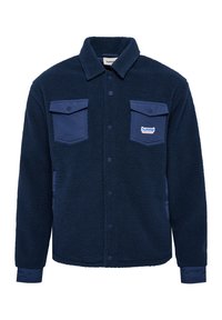 Marinblå fleecejacka med knappframsida, två bröstfickor med blåa lock och elastiska ärmslut. Tålig, varm look.