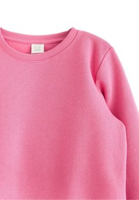 Rosa Sweatshirt mit geripptem Rundhalsausschnitt, langen Ärmeln und einem weichen, strukturierten Stoff. Keine sichtbaren Muster oder Hardwaredetails.