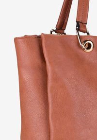Bolso tote de cuero marrón con un acabado texturizado, que cuenta con dos compartimentos y un acento de hardware en tono dorado. Las asas están reforzadas para mayor durabilidad.