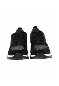 Baskets de sport noires en cuir lisse et en daim. Le design comprend une semelle blanche et un système de laçage.