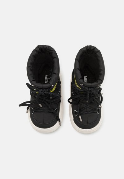 Svarta högsneakers med vadderad krage, texturerat tyg, kontrasterande vit sula och svarta snören med metalliska detaljer och gul branding.