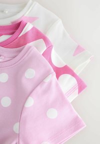 Trois t-shirts en coton à manches courtes ; un blanc avec des motifs géométriques roses, deux roses avec des pois blancs. Texture douce.