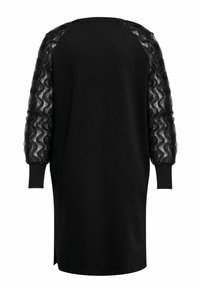 Svart kjole med puffede ermer i gjennomsiktig, rynket stoff. Designet inkluderer rund halsutringning og sideslisser ved kanten.