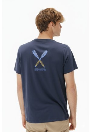 Camiseta de algodón azul marino con un gráfico de remos cruzados y el texto "EL PULPO" en la espalda. Mangas cortas, diseño de cuello redondo.