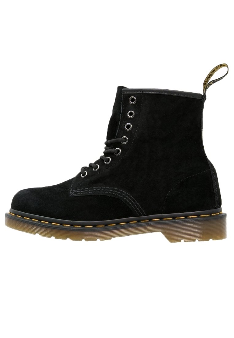 Botín de ante negro con cordones, costuras amarillas, suela translúcida marrón y tira de tela en la parte trasera.