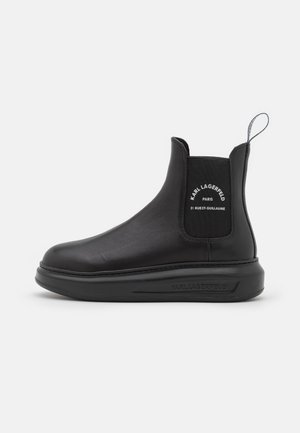 Bota Chelsea de cuero negro con panel lateral elástico y lengüeta para tirar, con la marca "KARL LAGERFELD PARIS" en el lateral y la suela, suela de plataforma plana.