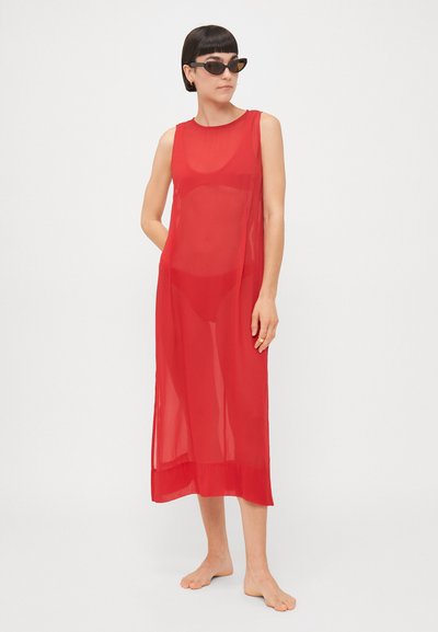 Abito rosso trasparente con design senza maniche, lunghezza lunga, vestibilità dritta e texture liscia, abbinato a occhiali da sole neri a forma di gatto.