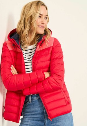 Red puffer jacket with a hood, featuring quilted texture, a navy collar, and zippered pockets, worn over a striped shirt.