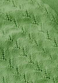 Tejido de punto en verde claro con un patrón de diamantes texturizado. Textura suave y difusa con una profundidad de puntada variable que crea un interés visual.