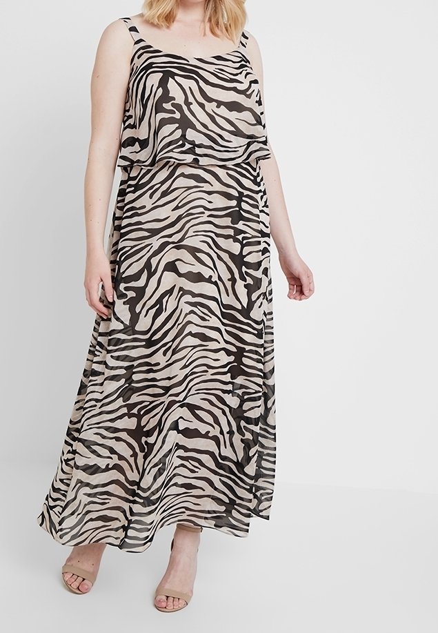 Robe longue en tissu transparent arborant un imprimé zèbre noir et beige, avec un design à couches et de fines bretelles. Texture lisse.