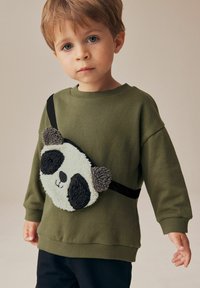 Grøn sweatshirt med en sort rem, der har en panda-formet taske. Tasken har en tekstur af fluffy materiale og kontrasterende sorte ører.