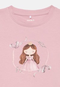 Κορίτσι καρτούν με μακριά καστανά μαλλιά, φορώντας ένα ροζ φόρεμα και χρυσό στέμμα, πλαισιωμένο από ασημένιες κορδέλες και μικρά ροζ λουλούδια σε ροζ ύφασμα.