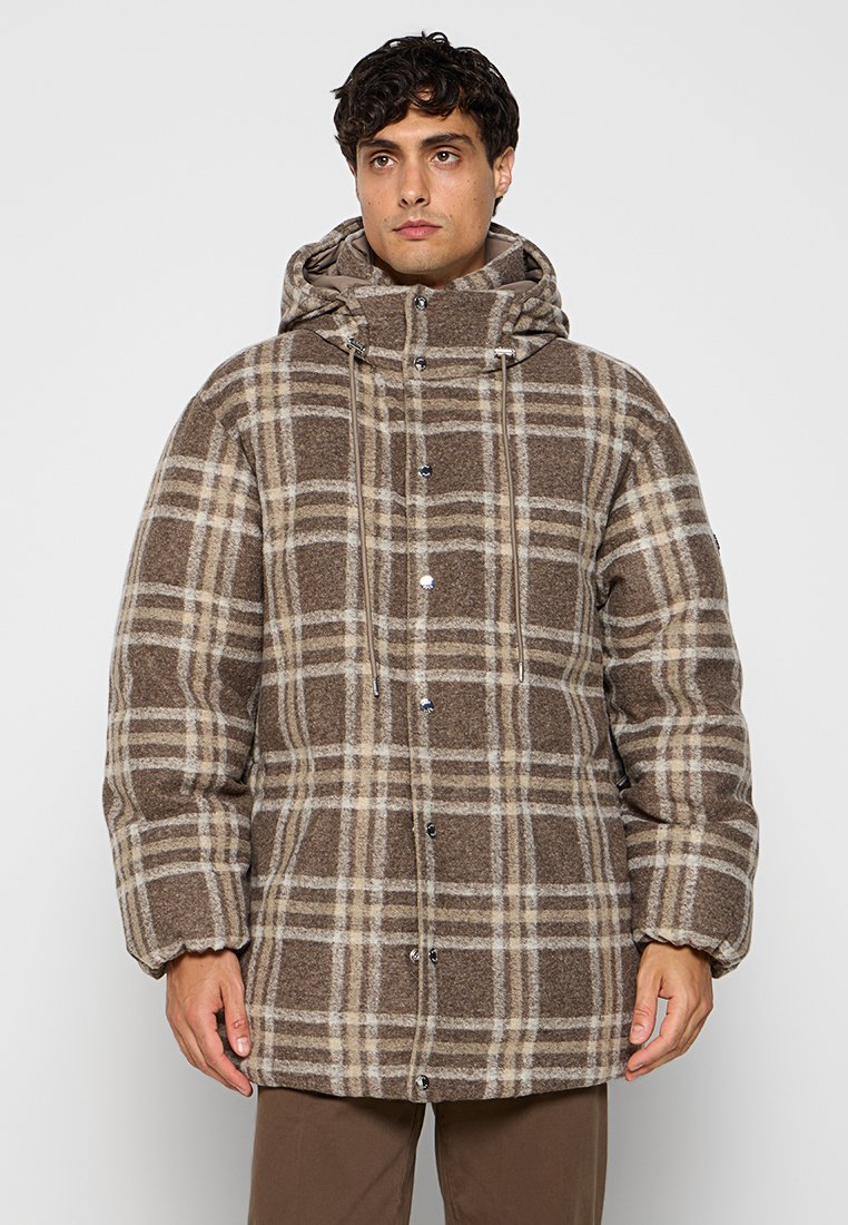 Doudoune à carreaux marron avec capuche, présentant des motifs à carreaux de couleur crème, des boutons-pression à l'avant et des cordons de serrage réglables au niveau du col.