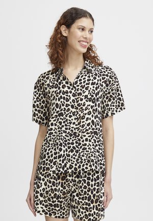 Löpartshirt med kort ärm i leopardmönster, tillverkat av slätt tyg, med en knapprad fram och en avslappnad passform. Matchas med kortbyxor i samma mönster.