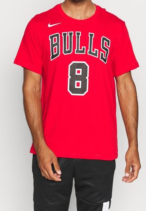 T-shirt en coton rouge avec "BULLS" en noir avec un contour blanc et le numéro "8" en noir, sur un fond uni.